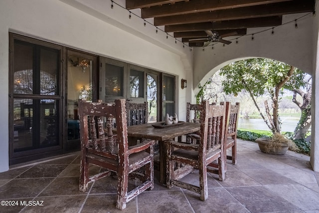 view of patio with ceiling fan and a water view