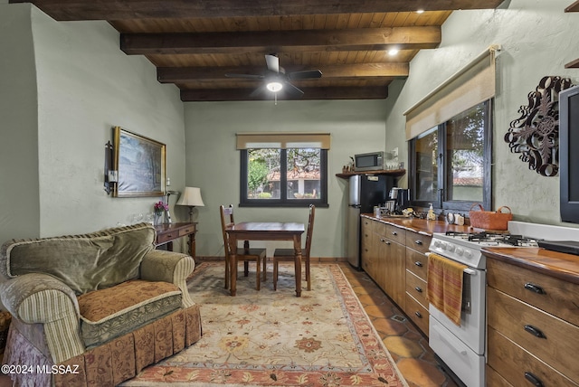 kitchen featuring beamed ceiling, ceiling fan, wood ceiling, and appliances with stainless steel finishes