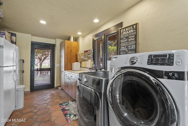 laundry room featuring washer and dryer and dark tile patterned flooring