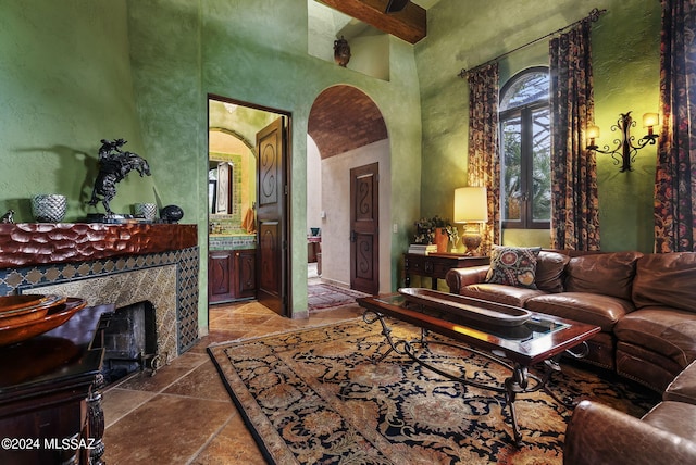 living room with beamed ceiling and a high ceiling