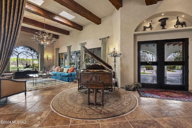 entrance foyer featuring french doors, a towering ceiling, a notable chandelier, and beam ceiling