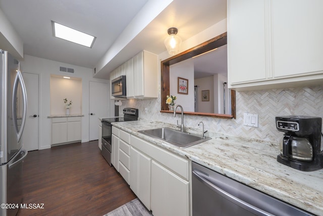 kitchen with stainless steel appliances, white cabinetry, tasteful backsplash, and sink