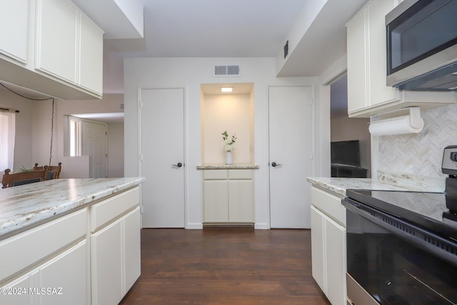 kitchen with backsplash, dark wood-type flooring, white cabinets, light stone counters, and stainless steel appliances