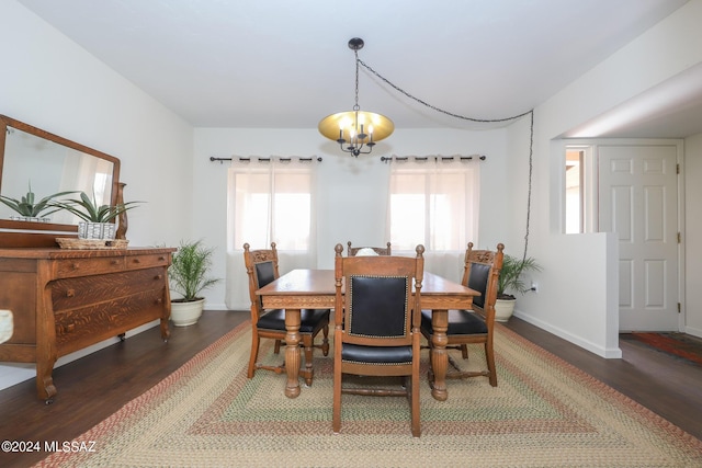 dining area with dark hardwood / wood-style flooring and a notable chandelier