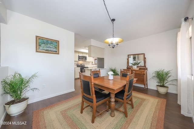 dining space featuring dark wood-type flooring and a notable chandelier