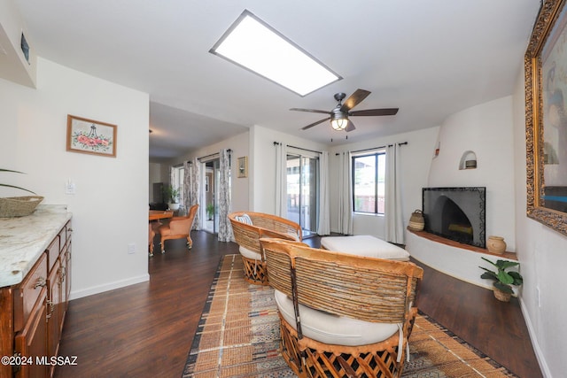 living room featuring ceiling fan and dark wood-type flooring