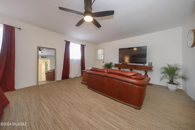 carpeted living room with ceiling fan