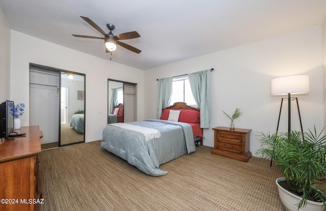 bedroom with carpet, ceiling fan, and two closets