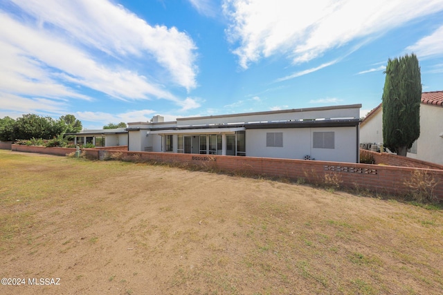 rear view of property with a yard