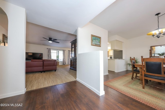 interior space with ceiling fan with notable chandelier and dark hardwood / wood-style flooring