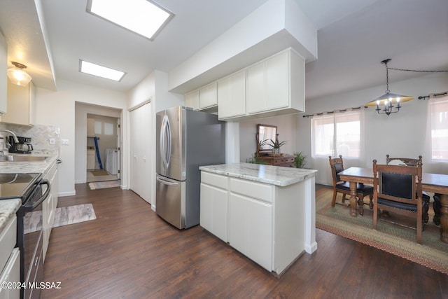 kitchen with white cabinetry, sink, black electric range oven, stainless steel fridge, and a chandelier