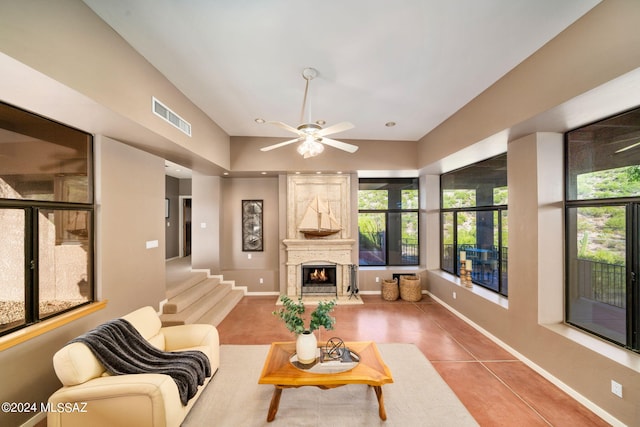 living room with tile patterned floors, ceiling fan, and a fireplace