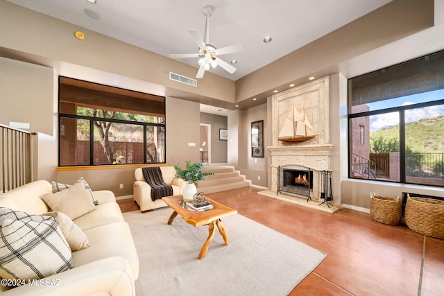 living room featuring ceiling fan and a fireplace