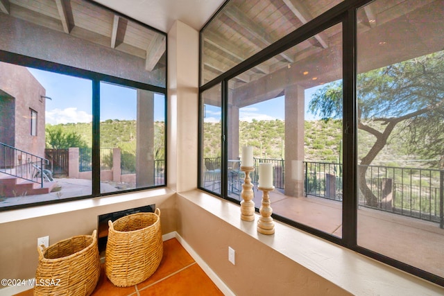 sunroom / solarium featuring beam ceiling and wood ceiling