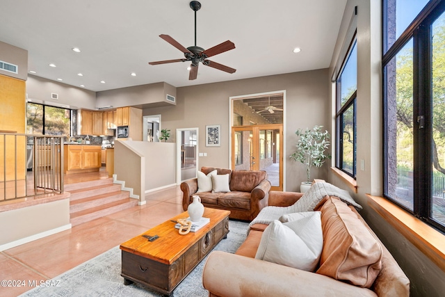 tiled living room with a high ceiling and ceiling fan