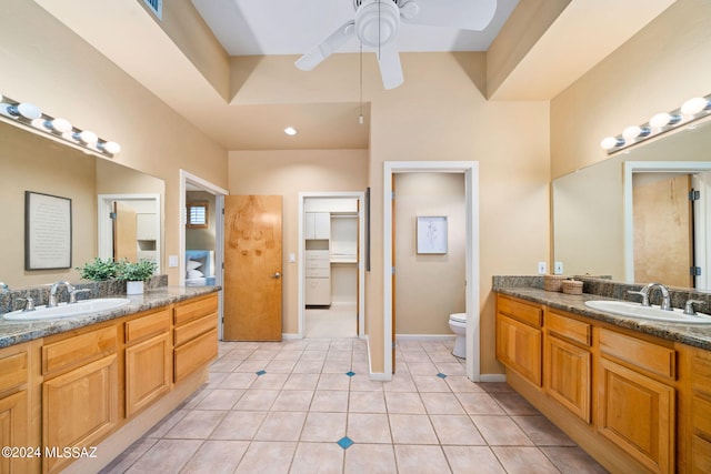 bathroom with tile patterned flooring, vanity, toilet, and ceiling fan