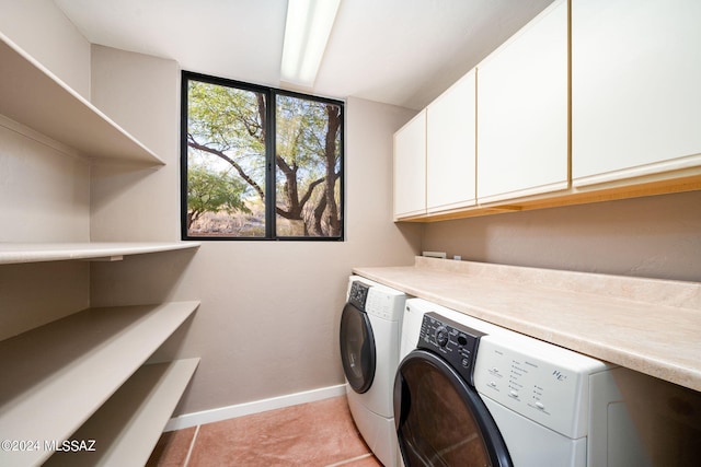 clothes washing area featuring light tile patterned flooring, cabinets, and washing machine and clothes dryer