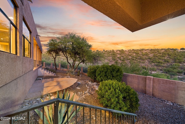 balcony at dusk featuring a patio area