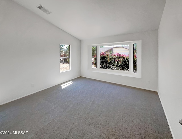 carpeted spare room with lofted ceiling