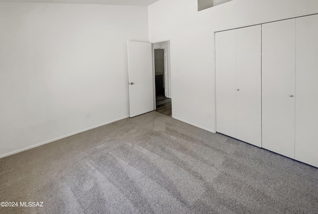 unfurnished bedroom with a towering ceiling and a closet