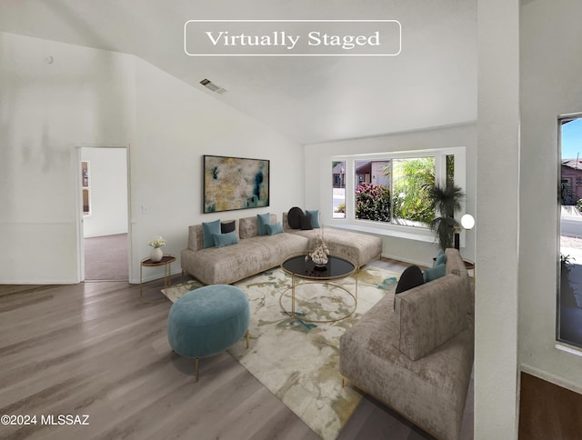 living room featuring high vaulted ceiling and hardwood / wood-style flooring