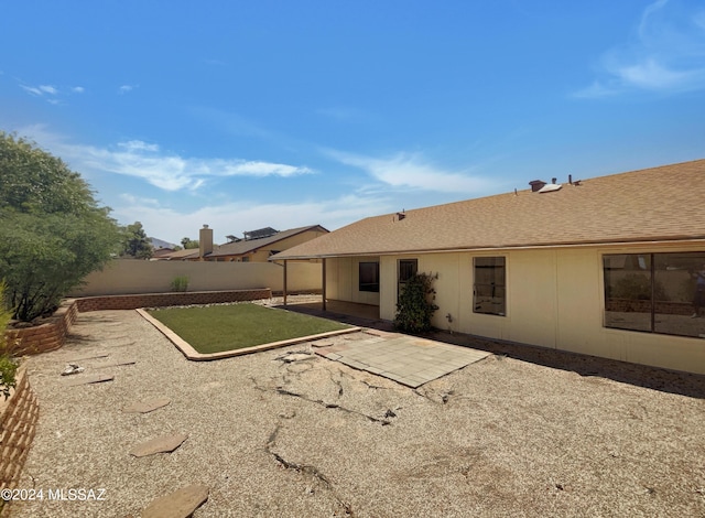 rear view of house with a patio and a lawn