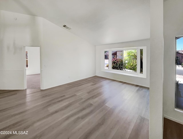 unfurnished living room featuring wood-type flooring and lofted ceiling