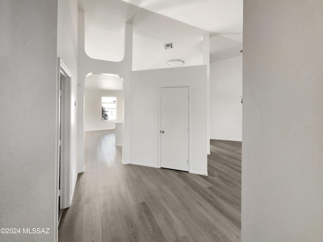 hallway featuring a high ceiling and light hardwood / wood-style flooring