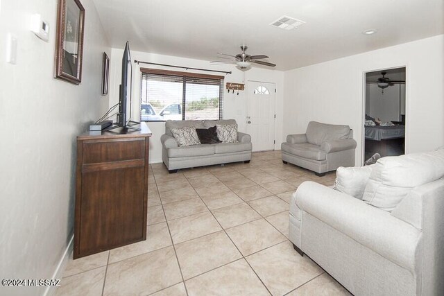 living area with ceiling fan, baseboards, visible vents, and light tile patterned floors