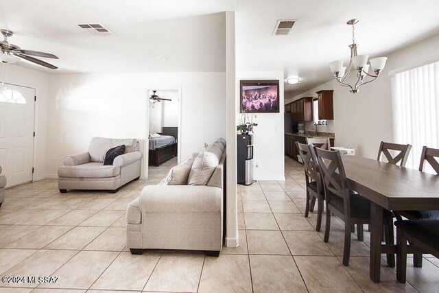 living room with visible vents, light tile patterned floors, and ceiling fan with notable chandelier
