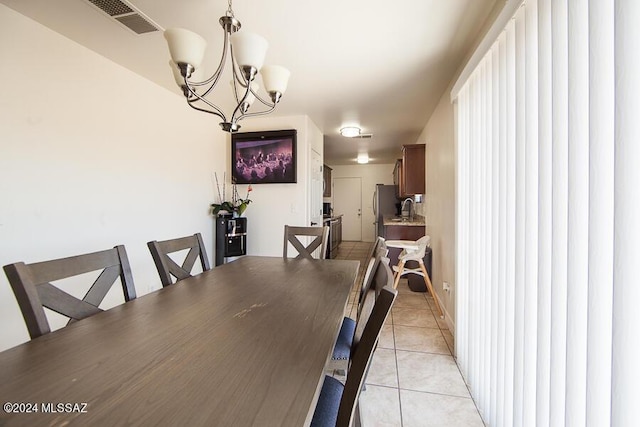 dining room featuring sink, light tile patterned floors, and a notable chandelier