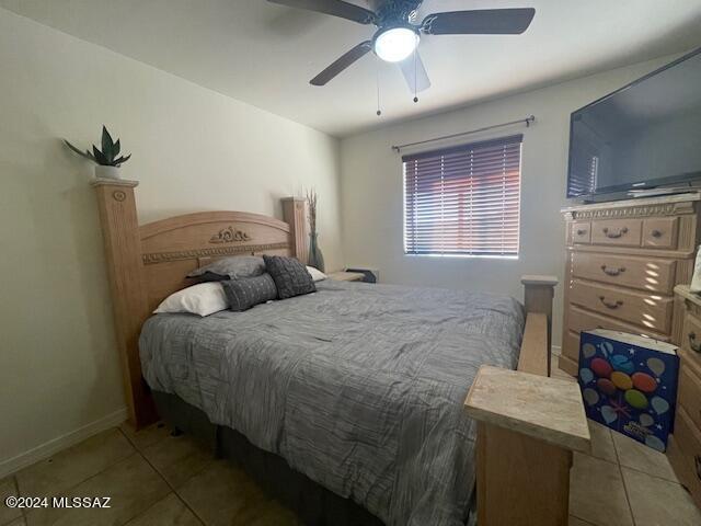 bedroom with tile patterned floors, baseboards, and ceiling fan