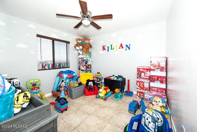 rec room with baseboards, a ceiling fan, and tile patterned flooring