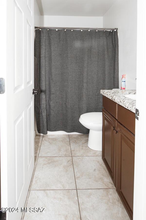 full bathroom with toilet, tile patterned floors, vanity, and a shower with shower curtain