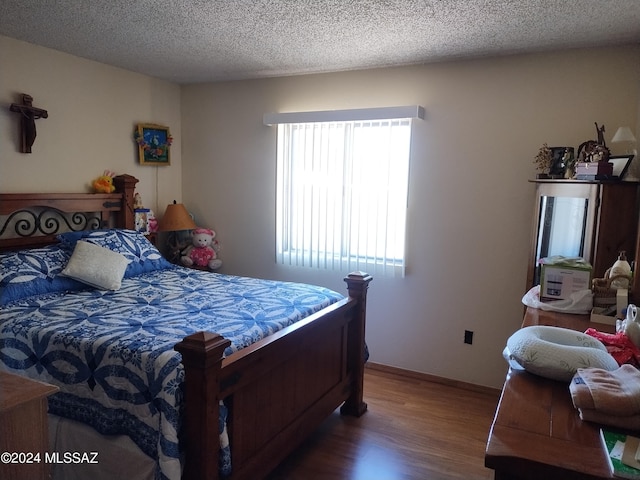 bedroom featuring hardwood / wood-style floors and a textured ceiling