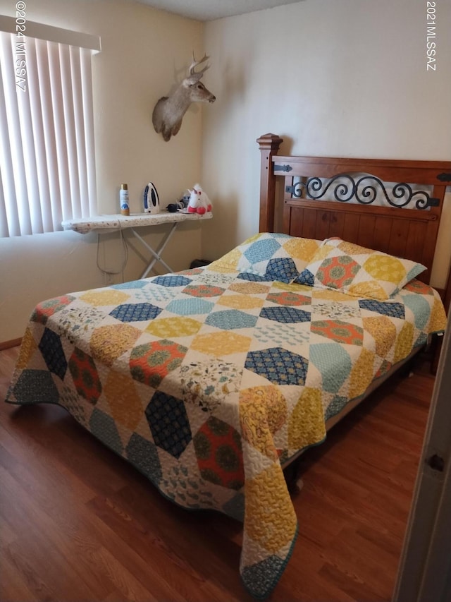 bedroom with dark wood-type flooring