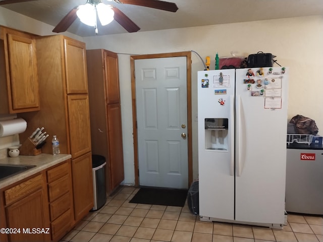 kitchen featuring light tile patterned floors, sink, white fridge with ice dispenser, and ceiling fan