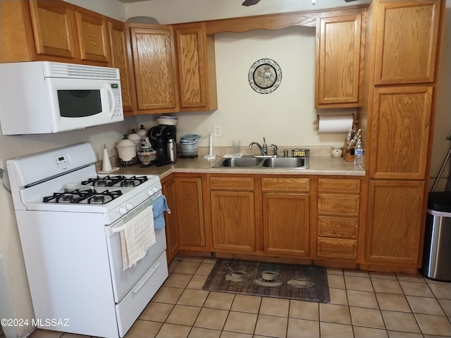 kitchen with light tile patterned flooring, white appliances, and sink