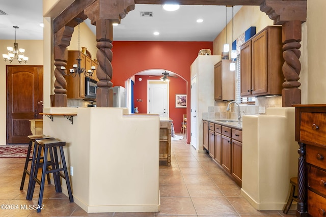 kitchen featuring pendant lighting, tasteful backsplash, a kitchen breakfast bar, and sink