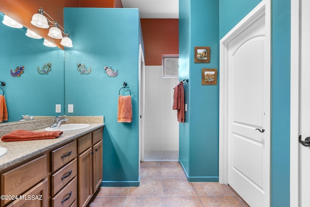 bathroom featuring tiled shower, vanity, and tile patterned floors