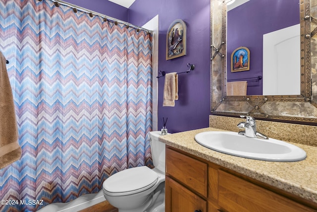 bathroom featuring curtained shower, vanity, and toilet