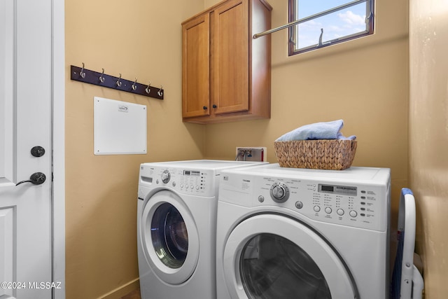 laundry area featuring washer and clothes dryer and cabinets