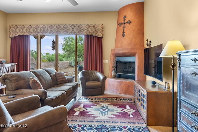 living room featuring ceiling fan and a fireplace