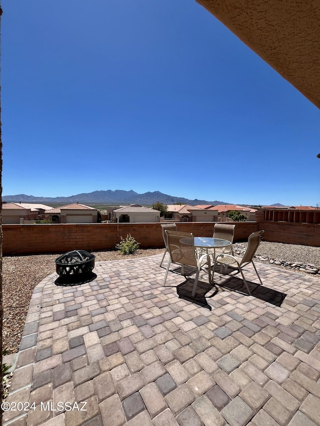 view of patio featuring an outdoor fire pit and a mountain view