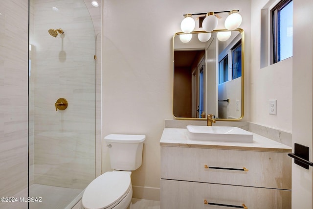 bathroom featuring tiled shower, vanity, and toilet