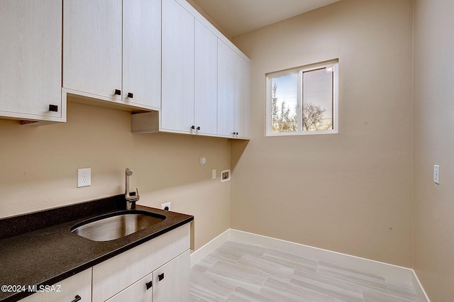 clothes washing area with sink, washer hookup, cabinets, and hookup for an electric dryer