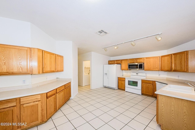 kitchen featuring light tile patterned floors, white appliances, and sink