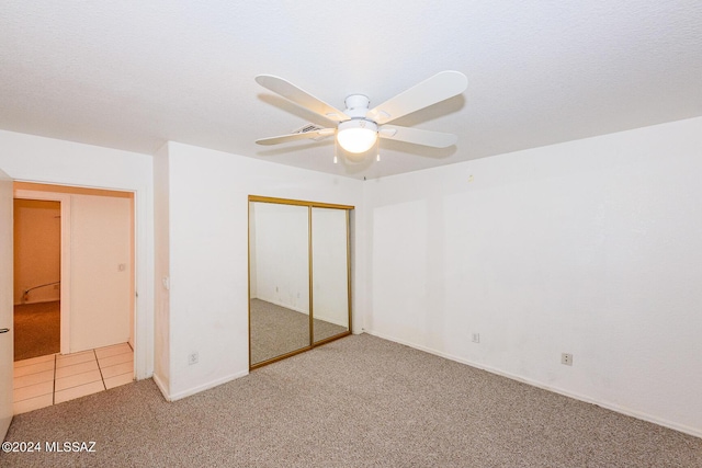 unfurnished bedroom featuring carpet flooring, a closet, and ceiling fan