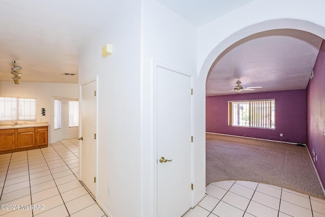 corridor with sink and light carpet