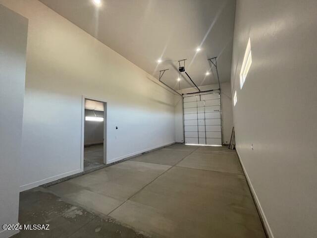 garage featuring a garage door opener and baseboards